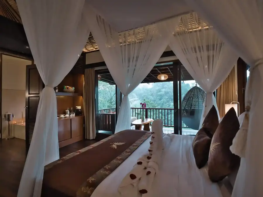 Canopy bed facing a jungle view in a high-end villa
